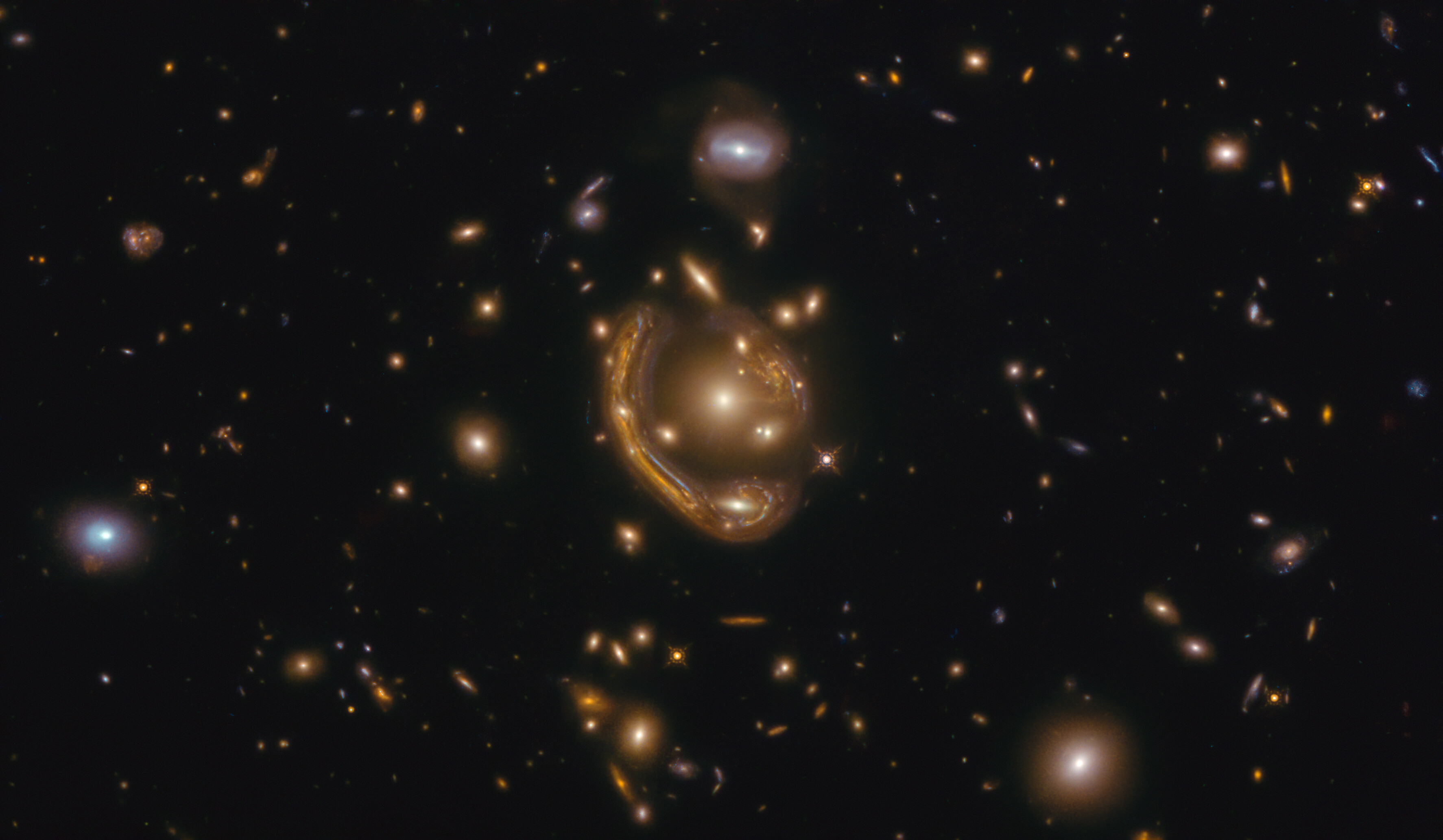Efecto de lente gravitatoria producido por un cúmulo de galaxias